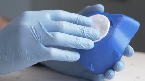 male wearing surgical gloves assembling a 3d-printed homemade mask during the covid-19 pandemic