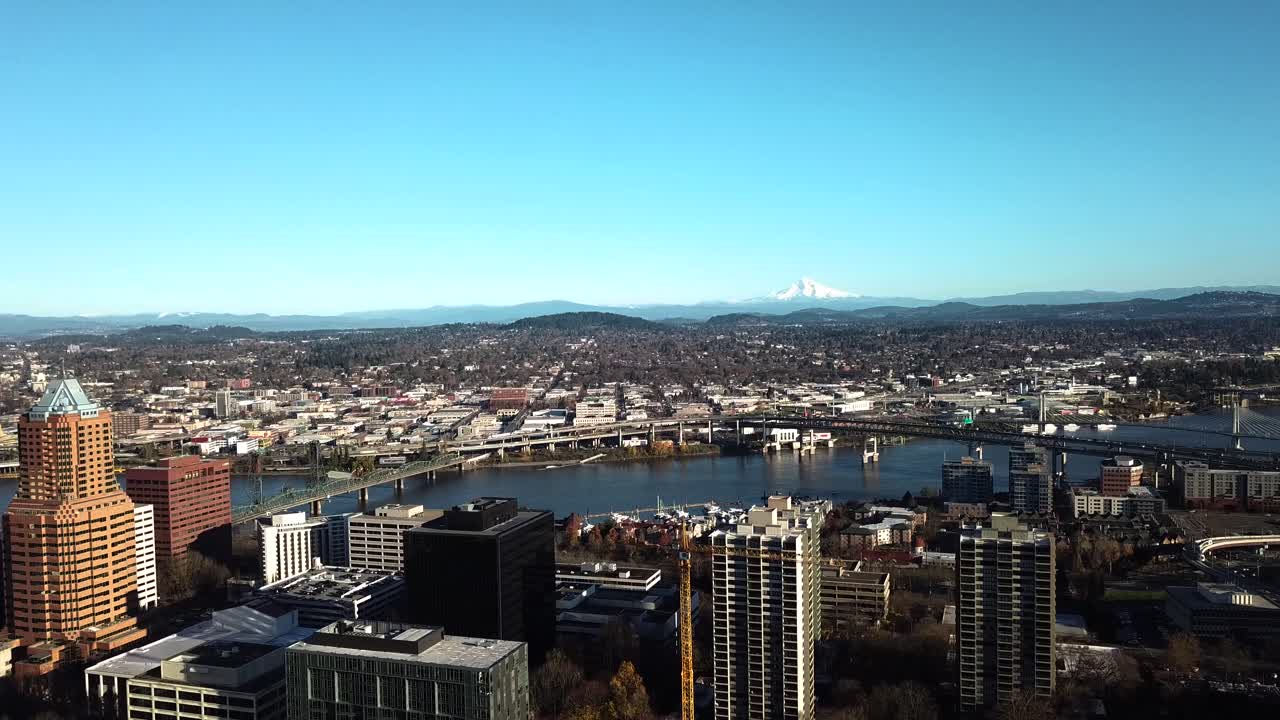 A panning aerial view of downtown Portland with Mount Hood looming in the distance.