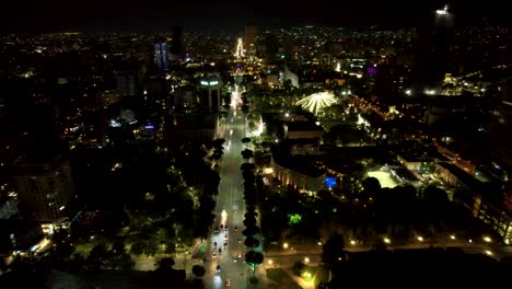 tirana capital de albania, bulevar principal, edificios institucionales e históricos iluminados por la noche, disparo aéreo de drones