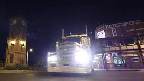 truck drives by a vintage hotel at night