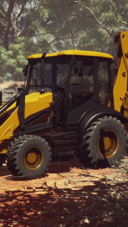 yellow backhoe excavator parked in a forest