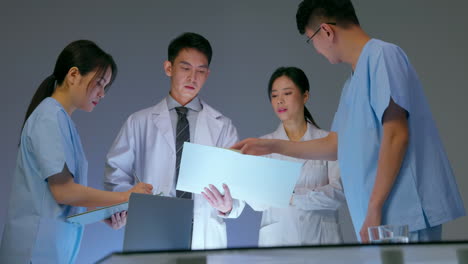 young doctors and team experts medical having meeting, using laptop and paper documents examining medical reports during work day in the hospital