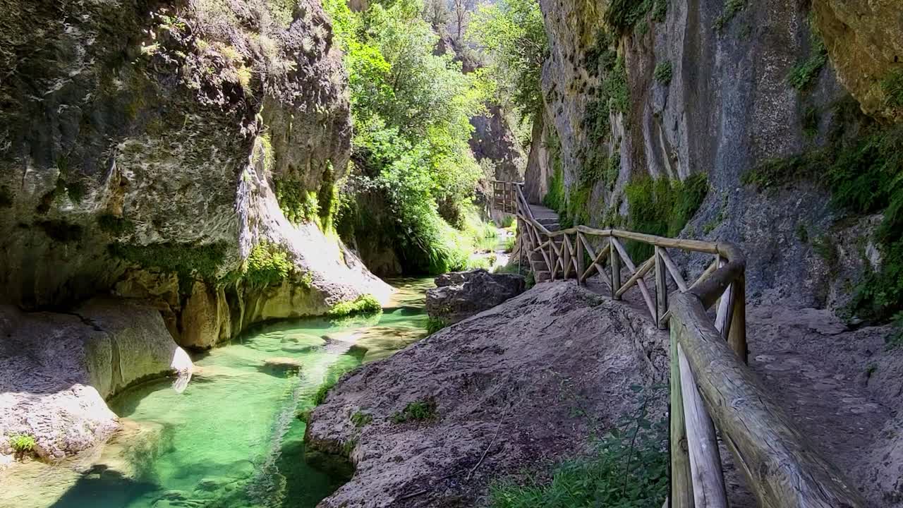 Beautiful turquoise river inside a gorge with a wooden walkway. Pure waters. Reflections of light on the rocks. Rio Borosa. Cazorla National Park. Spain