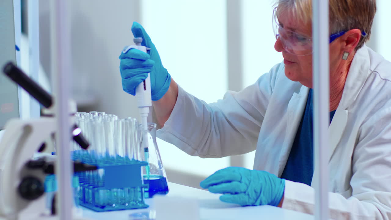 Scientist in medical laboratory examinining drug discovery using micropipette