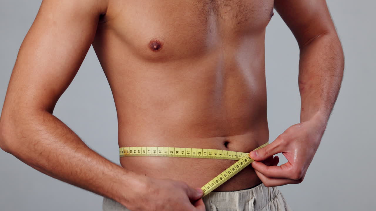 hombre midiendo su cintura con una cinta métrica