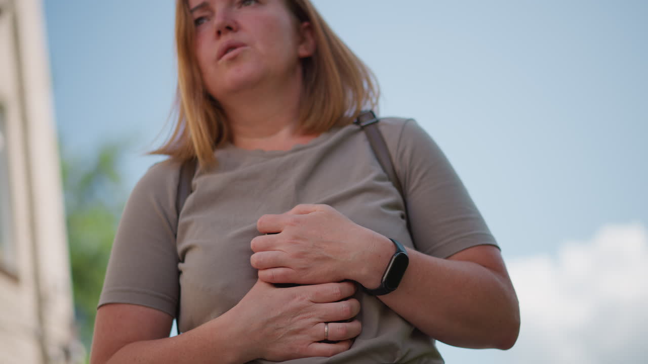 Young student holding smartphone outdoors under daylight, looking at screen with worried gesture, soft natural light highlighting face and hands, emotional moment showing anxiety