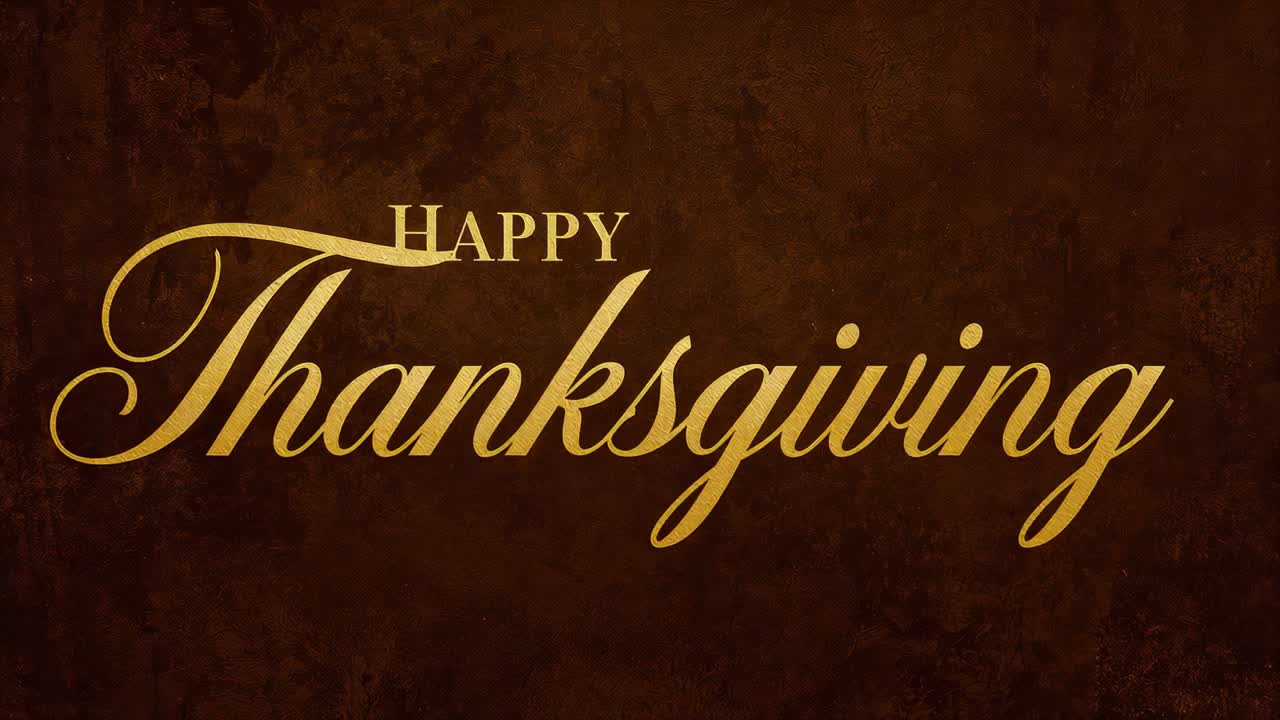 Su una scheda di gioco che mostra la scritta dorata HAPPY Thanksgiving centrata su uno sfondo marrone, che saluta gli spettatori