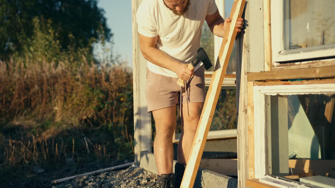 hombre recortando la superficie exterior de la madera con un hacha