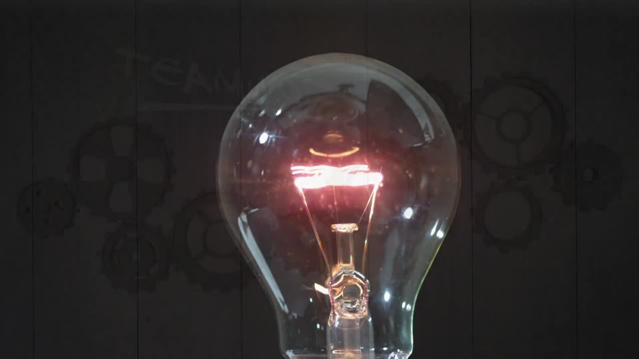 Animation of bulb lightening over brown background with gears