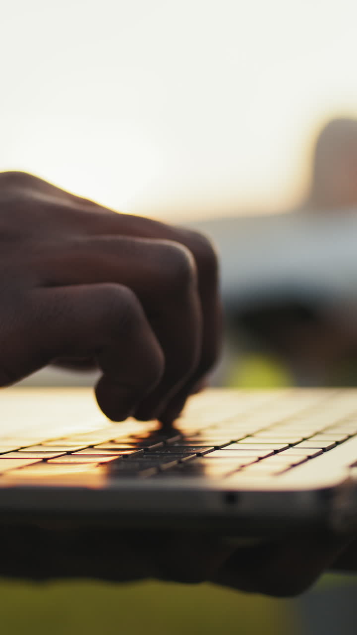 Typing on laptop at sunset
