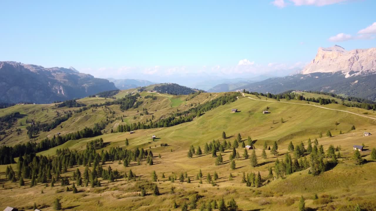 vista aérea de las laderas verdes de las montañas con chozas y árboles alpinos en verano en pralongia, dolomitas, italia