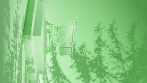 empty shopping cart on a green platform with shadow of branches on a green background