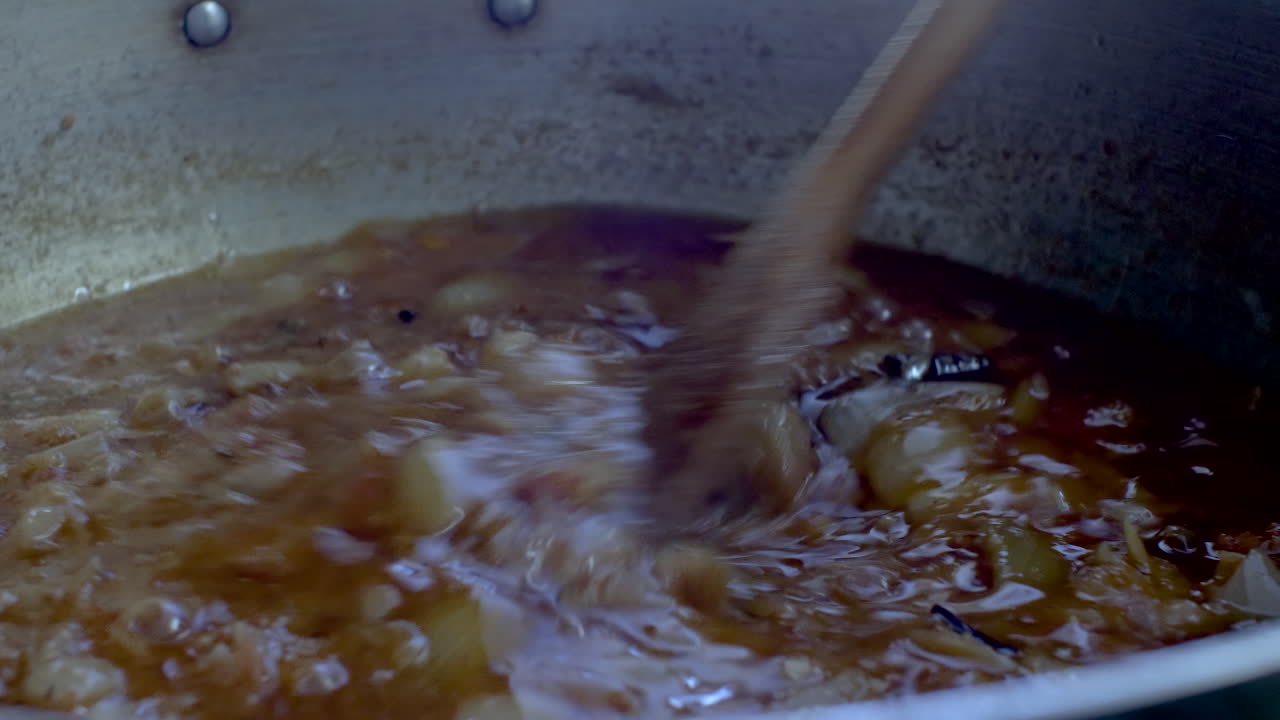 Wooden Spatula Stirring Simmering Curry Sauce With Onions-1