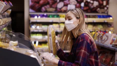 personal femenino con máscara trabajando en la sección de panadería del supermercado