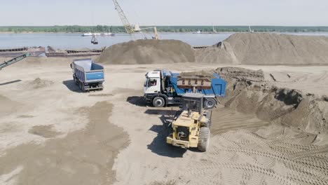 heavy equipment loading and unloading at a river port