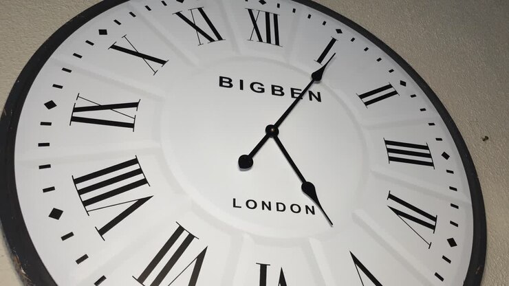 Time lapse of huge white wooden wall clock with london and big ben written on it, minutes quickly move past 5pm in the afternoon
