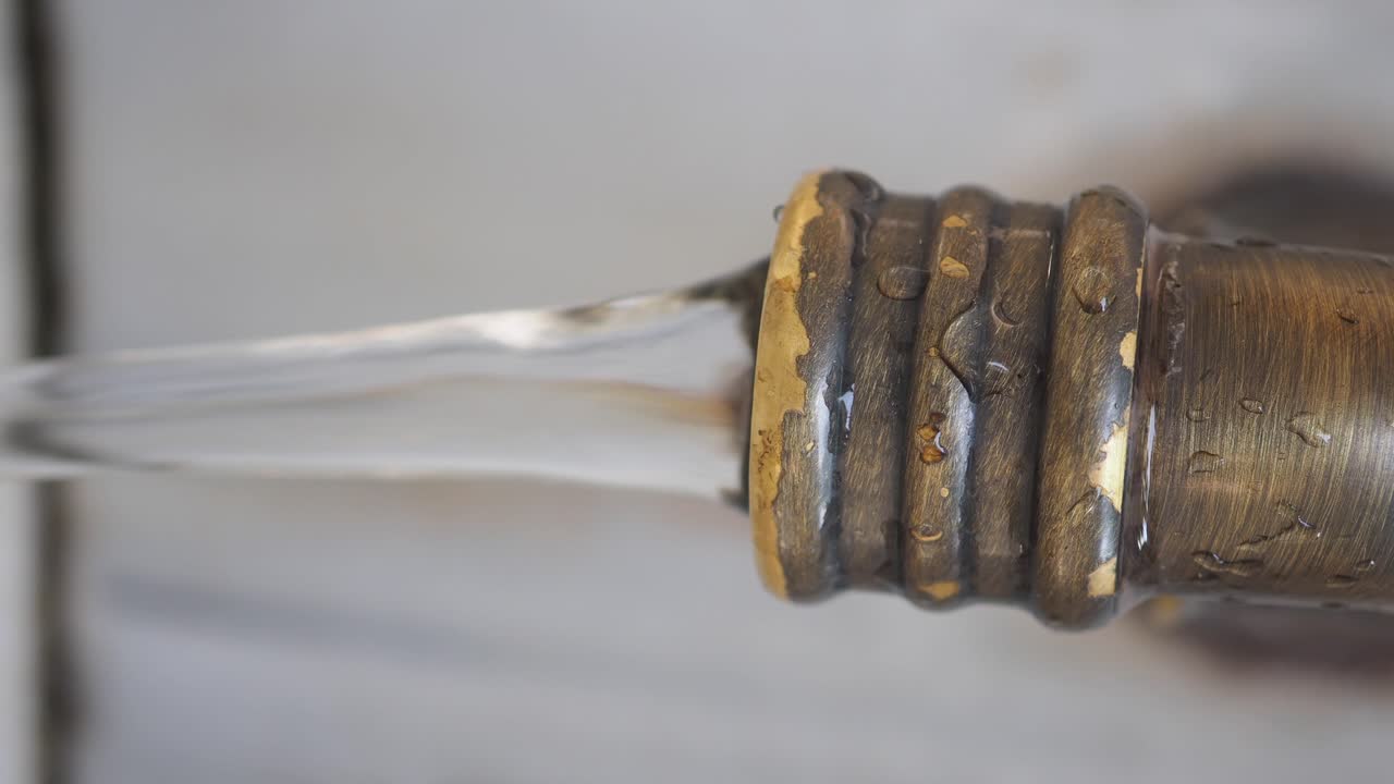 Close-up of Water Flowing from a Metal Faucet