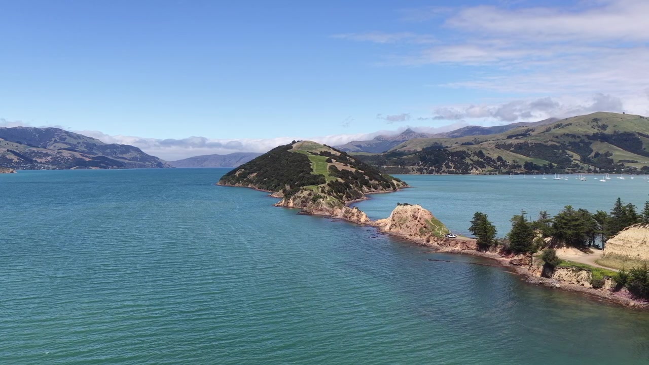 Vista aerea di una suggestiva penisola costiera circondata da acque blu calme sull'Isola del Sud della Nuova Zelanda, che mostra una costa frastagliata e baie tranquille.