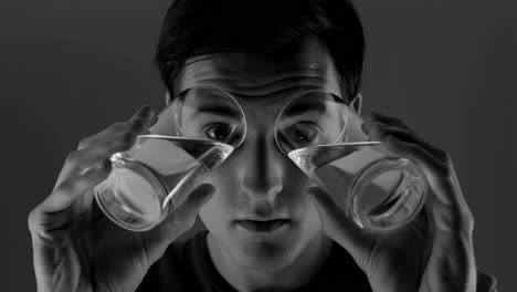man looking through water glasses distorting his vision