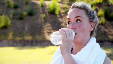 Frau-Wischt-Sich-Den-Schweiß-Ab,-Während-Sie-Nach-Dem-Training-Wasser-Trinkt