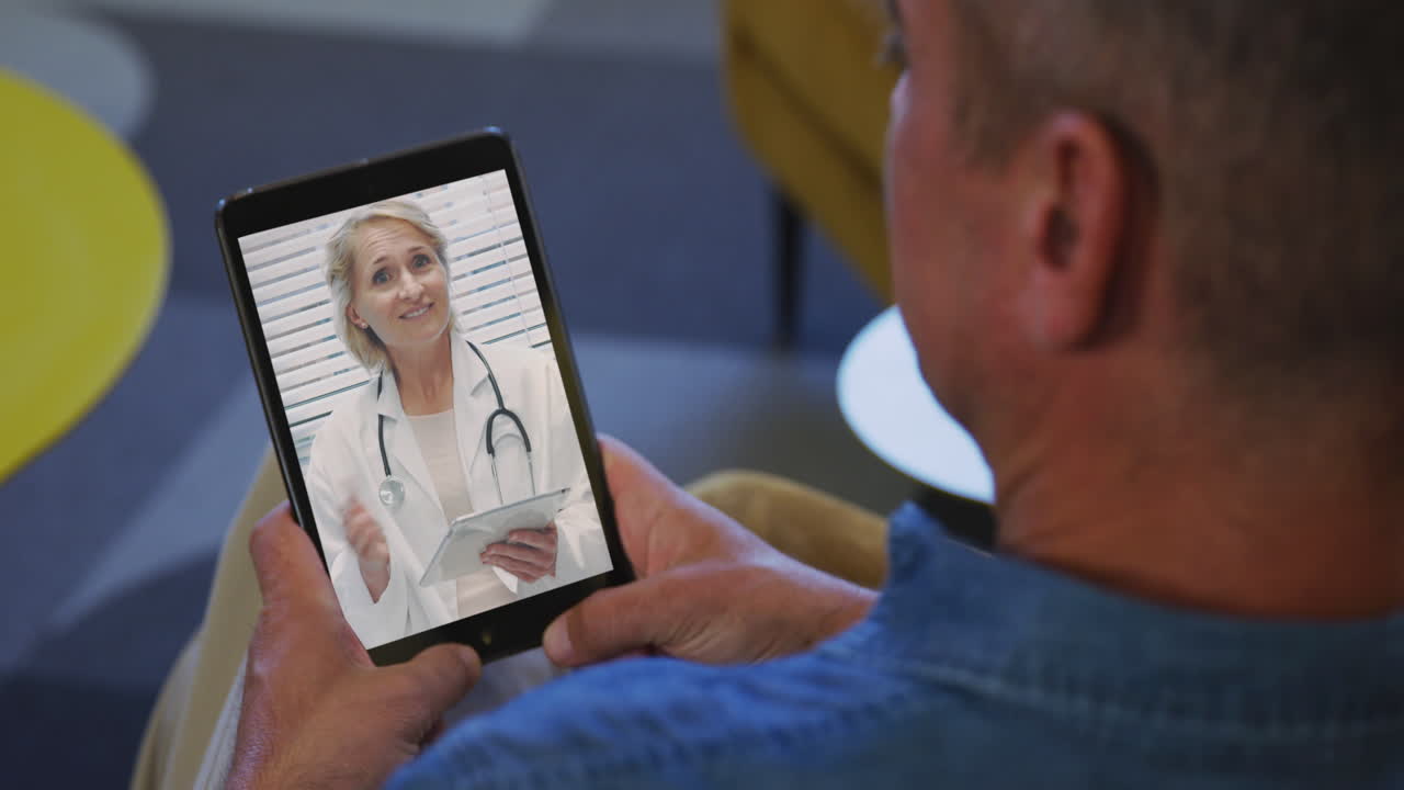 Hombre mayor haciendo una videollamada en su tablet en casa.