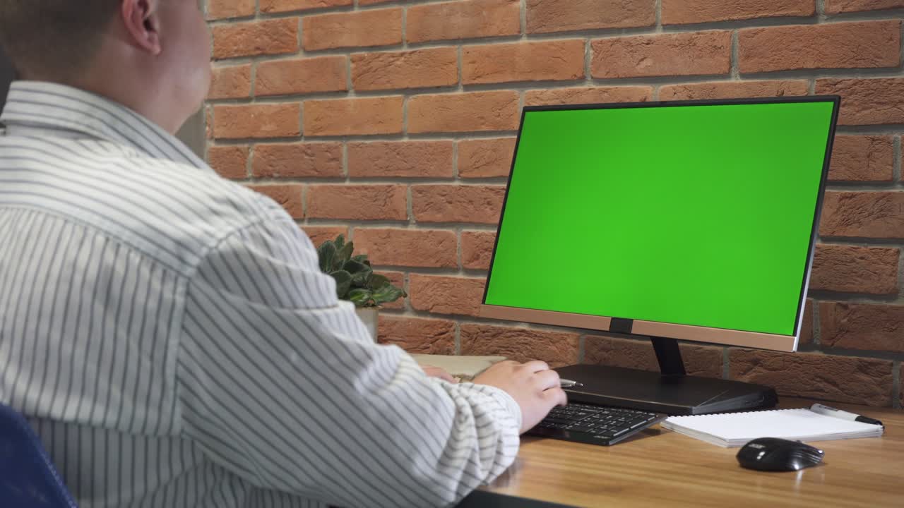 joven trabajando en una computadora con pantalla verde en la oficina. 4k