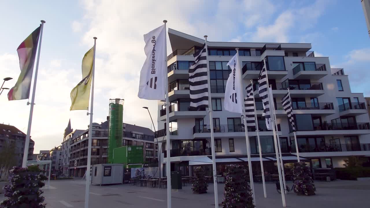 Flags of Belgium, Flanders and Blankenberge waving in the city center. Flags waving on steel poles - West-Flanders, Belgium