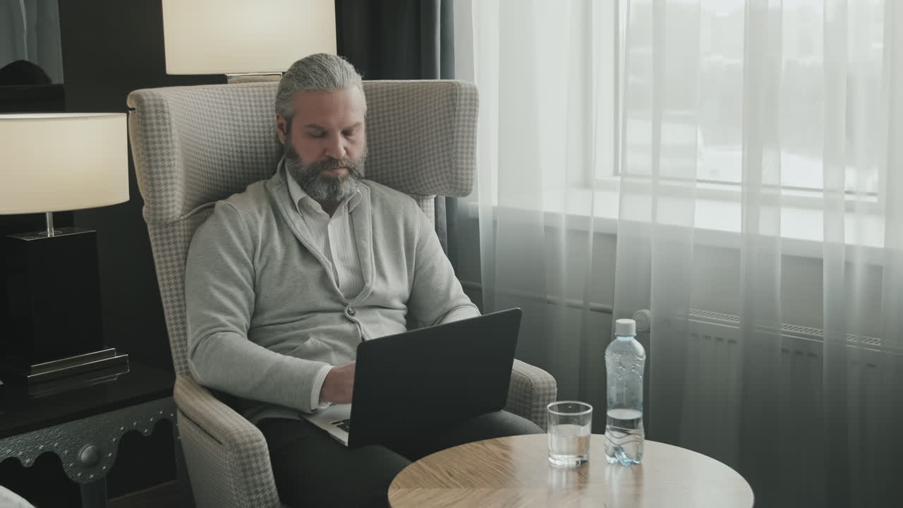 Businessman Working on Laptop in Hotel Room