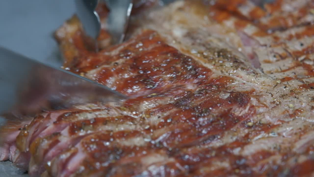 primer plano de cortar un jugoso bistec de cerdo recién salido de la barbacoa