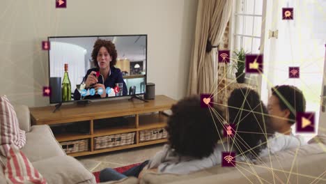 animation of network of connections with icons over african american family watching tv