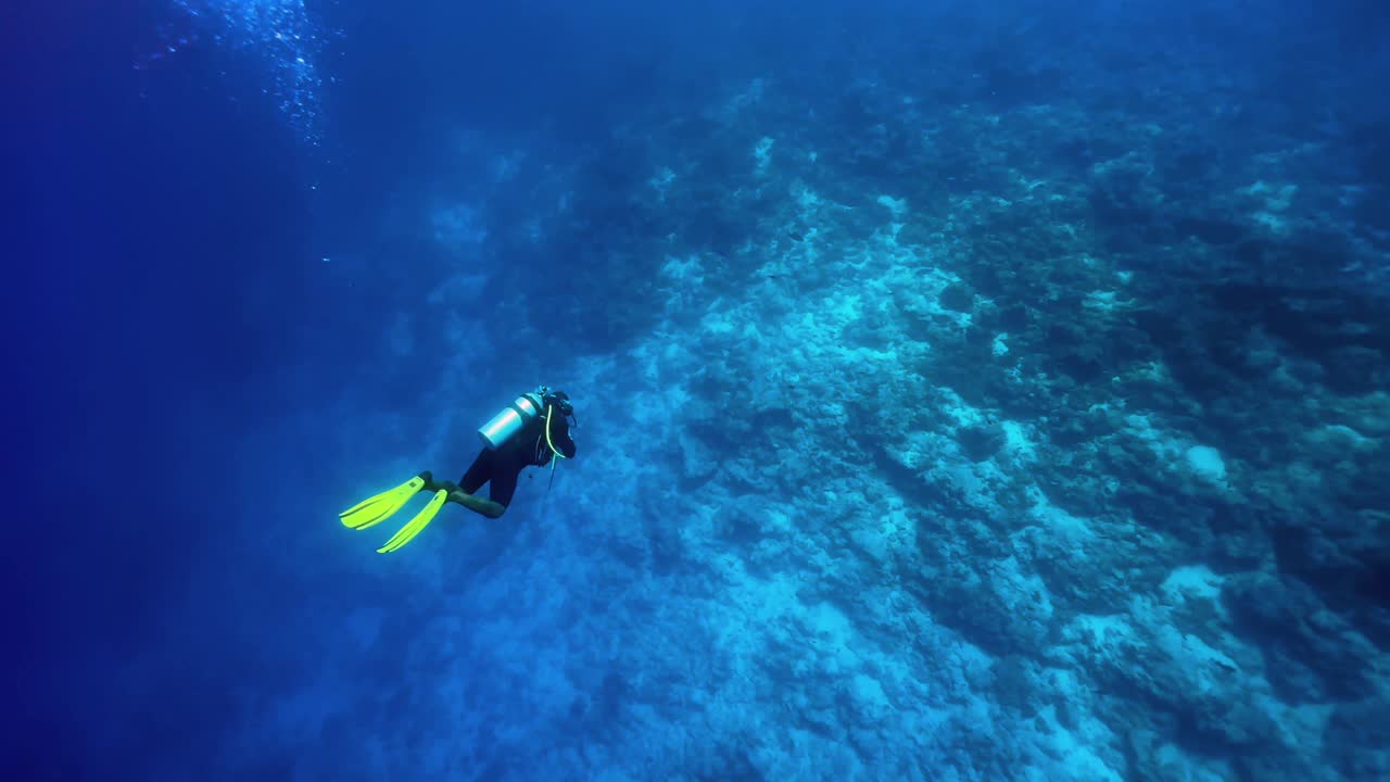 Scuba diver discovering dive site near Mnemba Island. Zanzibar, Tanzania.