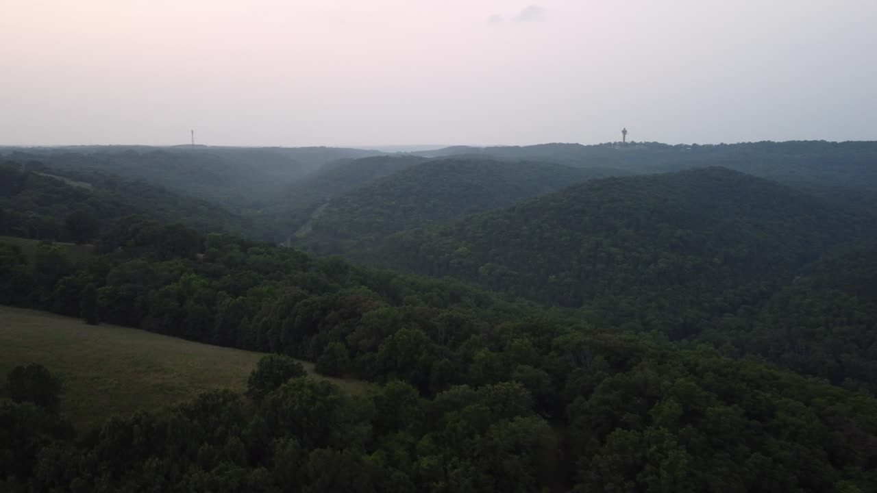 미주리 주 브랜슨에서 흐리고 안개가 자욱한 날 나무로 가득 찬 숲 위로 공중 촬영