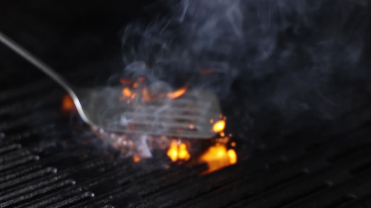 Bistecca che prende fuoco su una griglia calda