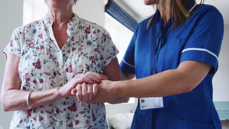 nurse helping senior woman with walking, mid section