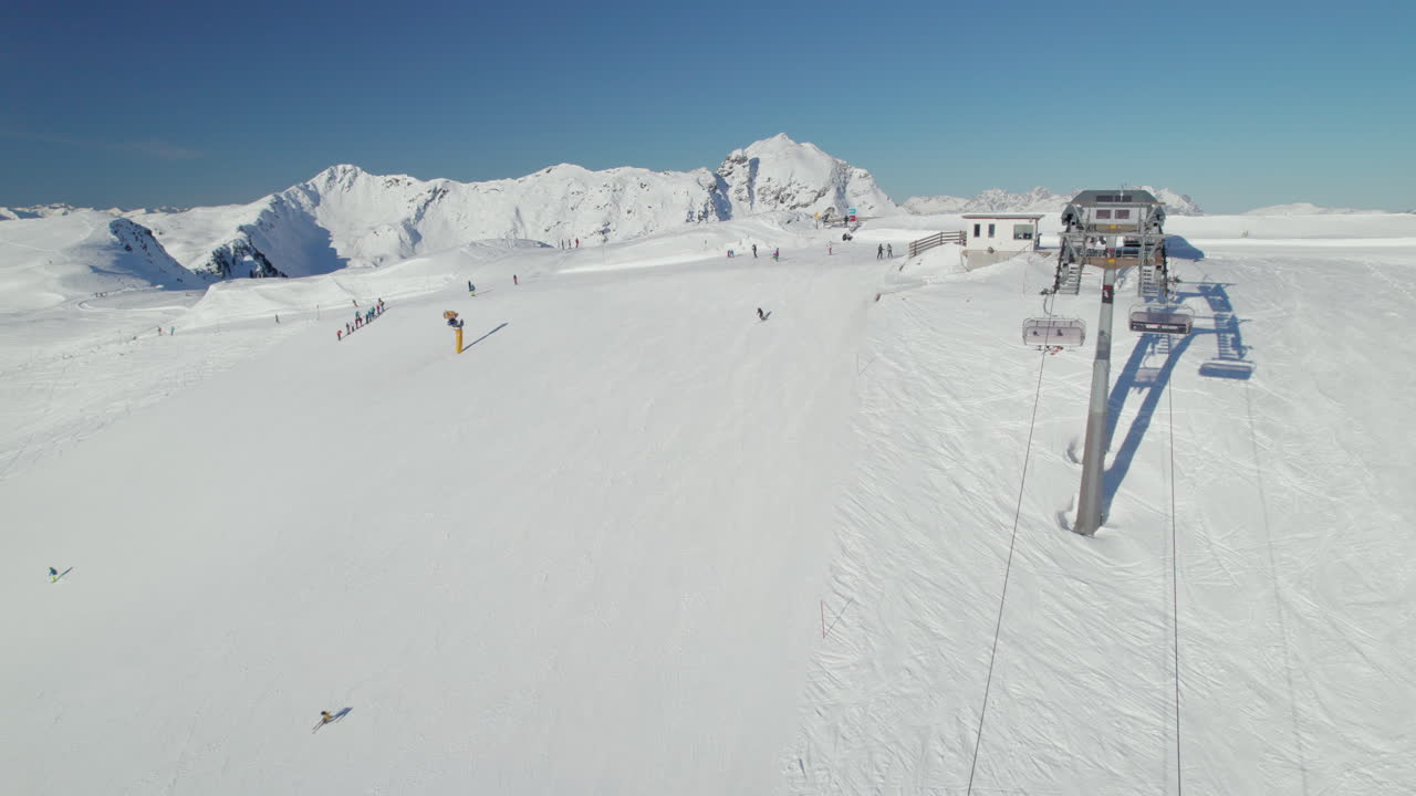 воздушный вид лыжного лифта, лыжников и сноубордистов на заснеженном склоне в саальбахе-хинтерглемме, австрия - снимок с беспилотника