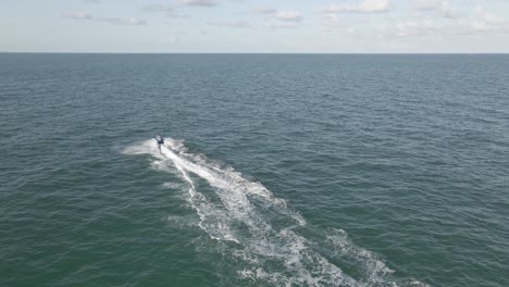 jet ski bursts onto empty ocean scene, runs diagonally across frame