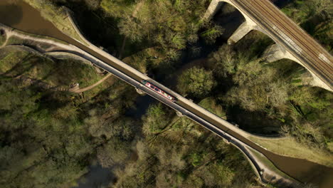 barcaza de barco de canal que viaja a lo largo del canal desde arriba en la campiña inglesa toma aérea giratoria