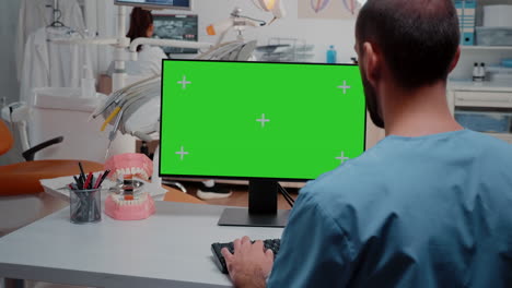hombre mirando una computadora con una pantalla verde horizontal