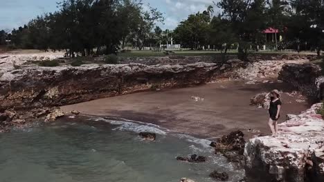 mujer de pie en el borde del acantilado cerca de la apartada playa de darwin