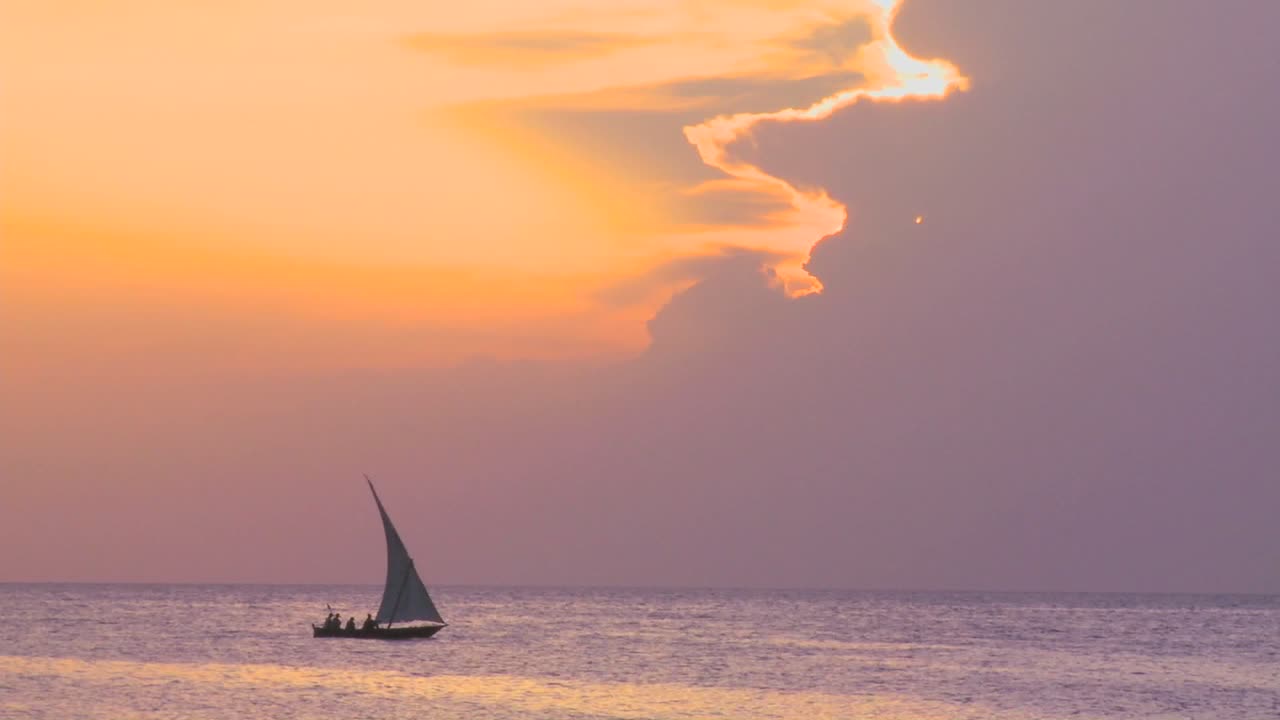 황혼에 잔지바르 해안을 따라 미끄러지는 아름다운 도우 범선