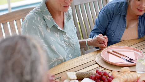 Senior-biracial-woman-holds-hands-with-someone-at-a-table