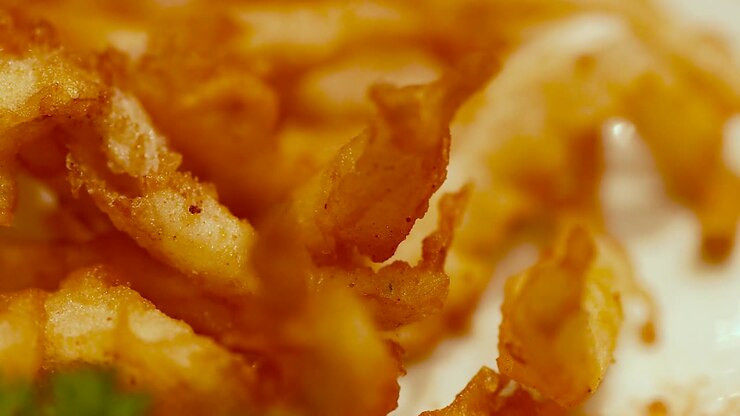 Macro shot of crunchy fried seafood snacks with warm lighting and fresh parsley garnish