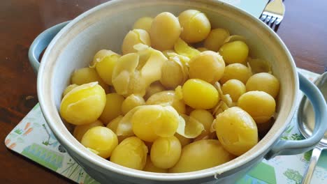 delicious boiled hot new potatoes with melting butter steaming in serving dish for sunday roast lunch and dinner