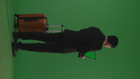 businessman with suitcase and tablet on green screen