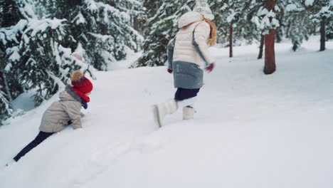 kids play and jump in snowy forest. toddler jumping on snowdrift. child playing with snow in winter.