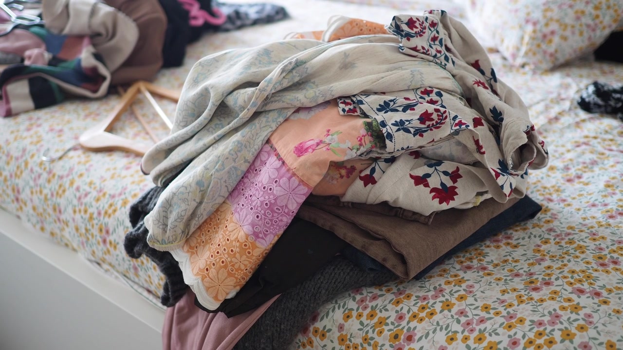 Pile of Folded Clothes on a Floral Bedspread
