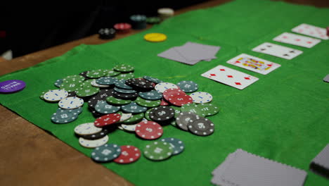 camera focuses on poker chips and playing cards on the table