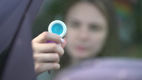 woman using pop it or simple dimple in car.