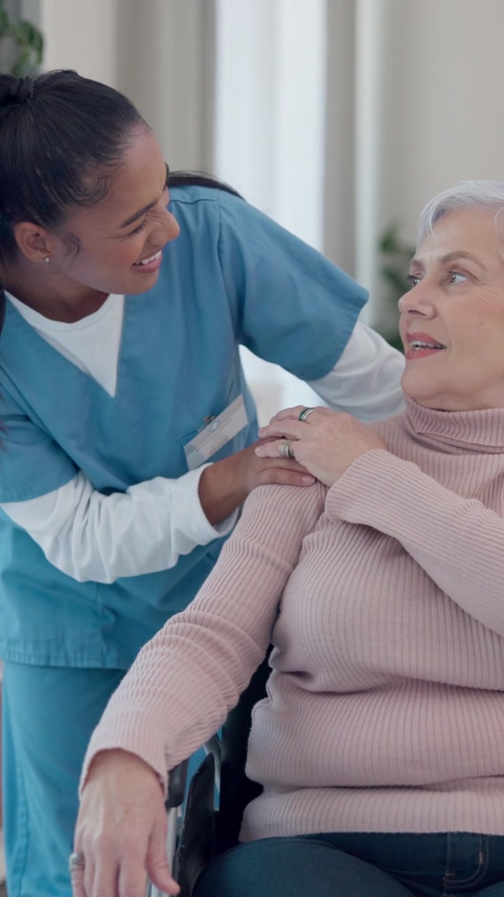 Young Nurse Comforting Senior Woman in Wheelchair