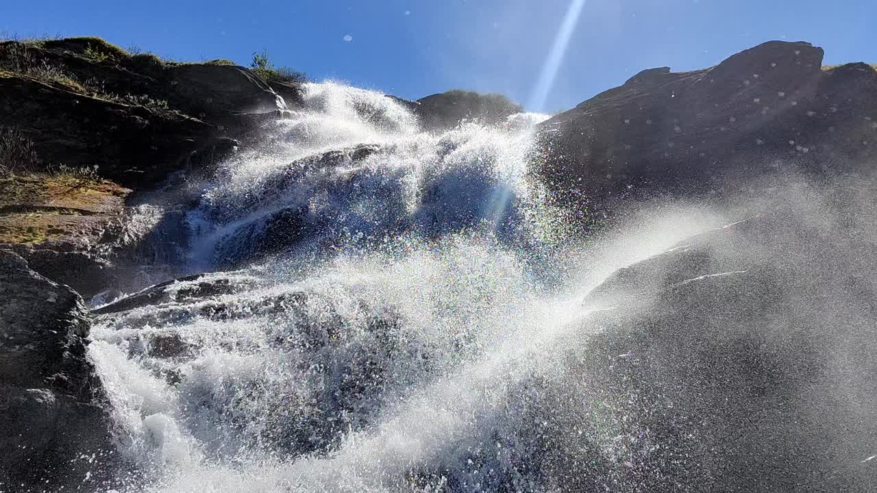 노르웨이 vikafjell 산의 아름다운 햇빛에 강력한 물보라 - 푸른 하늘과 카메라가 거의 폭포의 아래쪽 부분에 있는 봄 - 폭포를 올려다보는 낮은 각도